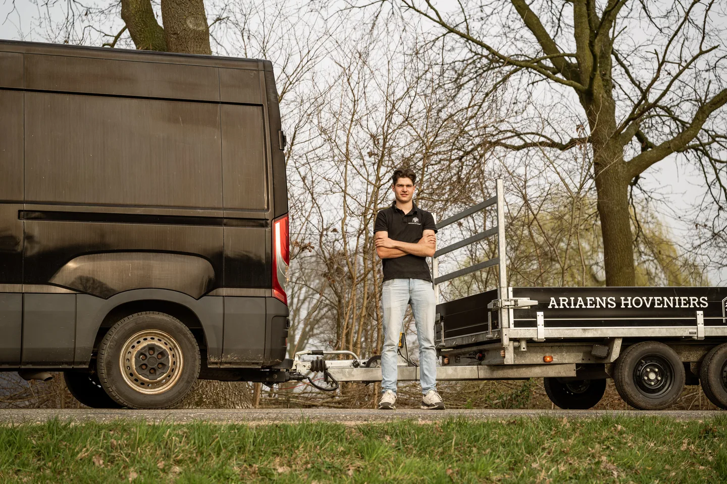 Hovenier naast de werkbus in een groene omgeving