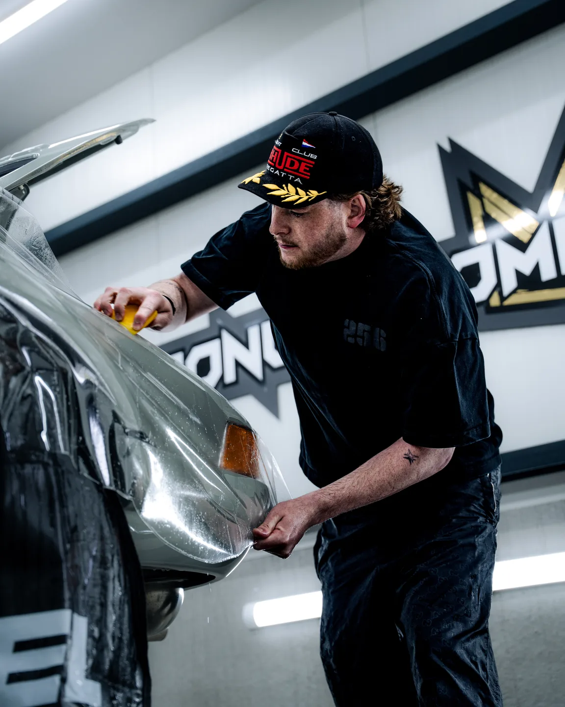 Specialist van Kroon Customizing werkt aan een auto