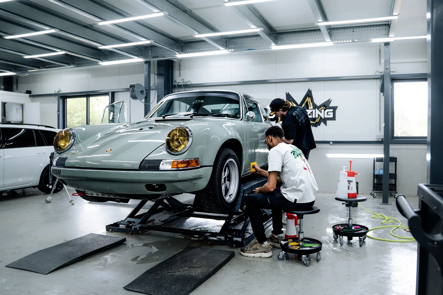 Team rond een auto in de werkplaats