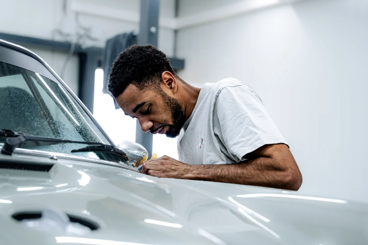 Specialist werkt aan de deur van een witte auto
