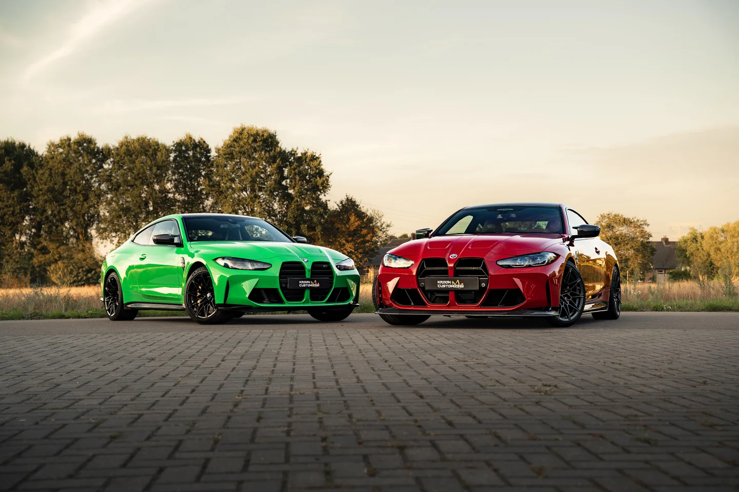 Groene en rode BMW samen in warm avondlicht