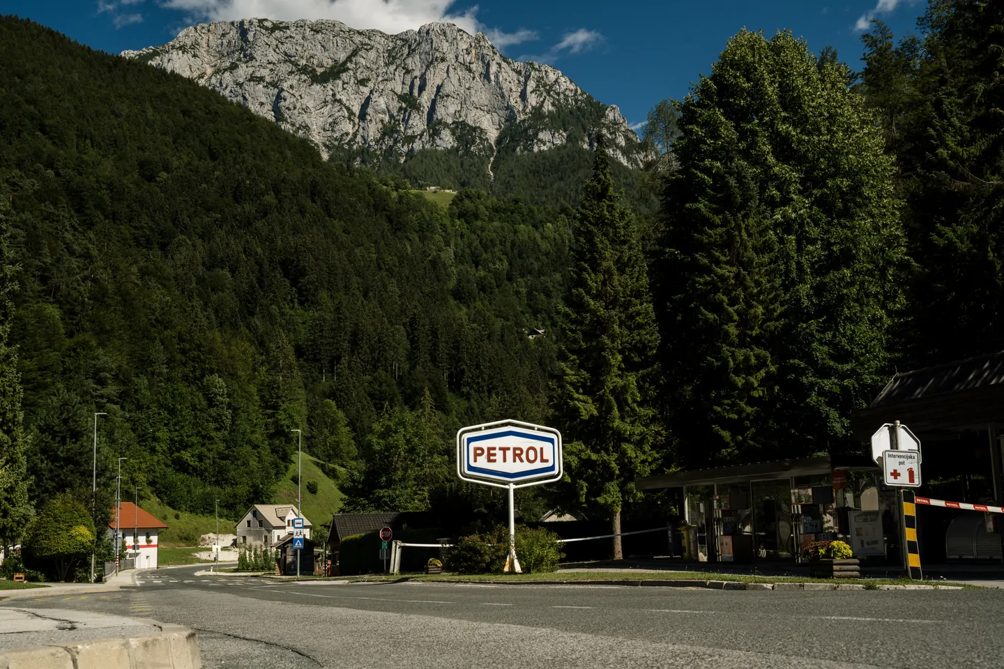 Klassiek tankstationbord in een berglandschap