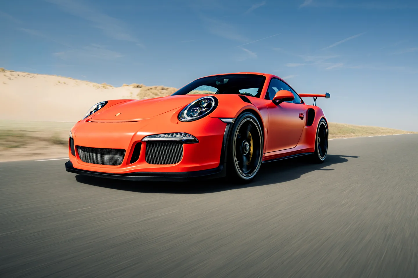 Rode Porsche GT3 RS gefotografeerd in beweging op de weg