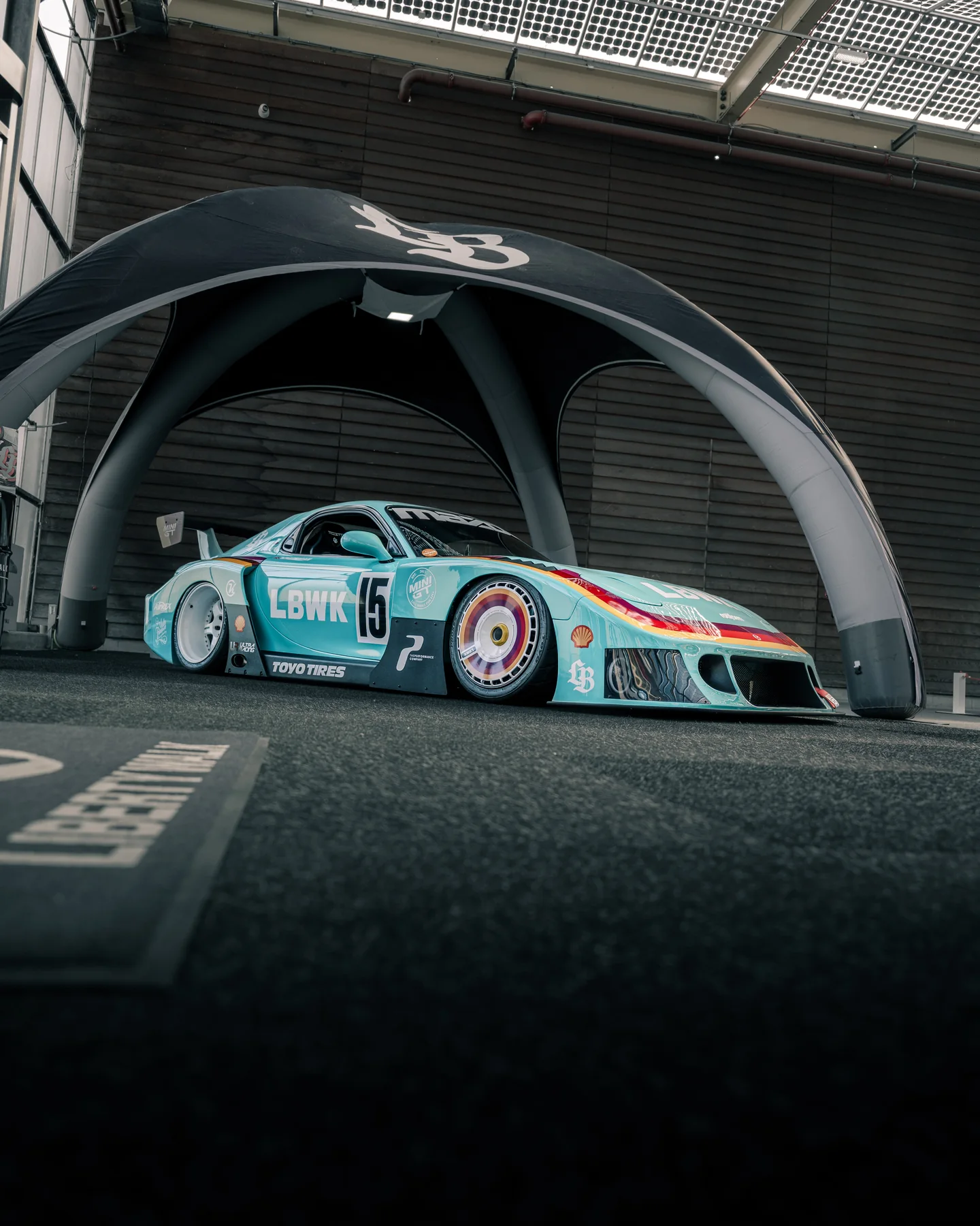 Raceauto onder een moderne betonnen boog